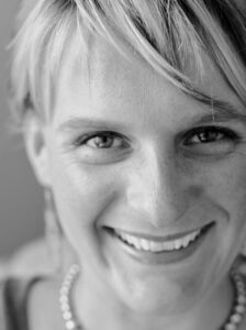 White woman with short blonde hair smiling